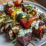 Colorful summer grilled veggie skewers with chimichurri, featuring charred zucchini, peppers, and mushrooms.