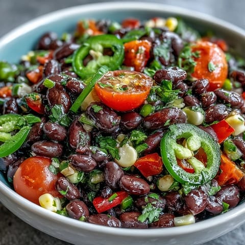 Fresh Cowboy Caviar in a white bowl with chips and lime wedges for dipping